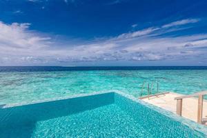 Luxury travel lifestyle landscape, seascape. Infinity swimming pool with amazing sea view. Perfect summer vacation concept. Blue colors of sea, ocean