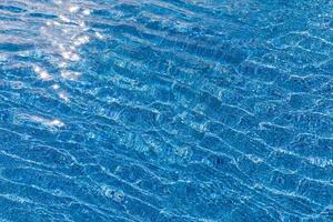 Beautiful pool water with relaxing sun sparkles on surface. Summer vacation or holiday concept, swimming pool texture photo