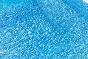 Beautiful pool water with relaxing sun sparkles on surface. Summer vacation or holiday concept, swimming pool texture photo