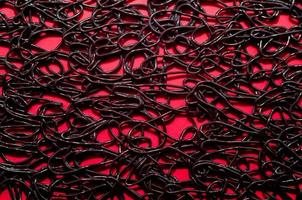 texture pattern of dark brown rubber on a red background photo