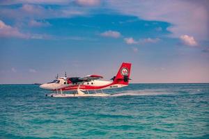 08.09.2019 - Ari Atoll, Maldives Exotic scene with seaplane on Maldives sea landing. Seaplane taxi on sunset sea before takeoff. Vacation or holiday in Maldives concept background. Air transportation photo