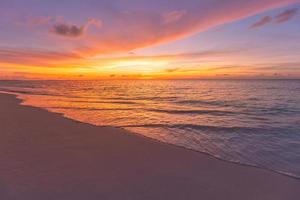 paisaje marino al atardecer. colorido amanecer en la playa del océano. hermoso paisaje de playa con olas tranquilas y playa de arena suave. paisaje tropical vacío, horizonte con vistas panorámicas a la costa. colorido naturaleza mar cielo foto