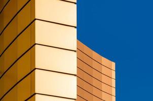 fragment of the wall of a modern yellow building on a blue background photo