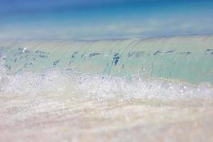 Tropical sea and sand under the blue sky. Tropical beach landscape. Soft blue ocean wave on clean sandy beach. Ocean wave background. White sand and crystal-blue sea. Ocean water nature, beach relax photo