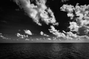 Dramatic sea view, monochrome  seascape, white clouds dark deep ocean bay. Coastline in black and white, abstract sky. Exotic Mediterranean tropical sea view. Dream motivation and inspire Earth nature photo