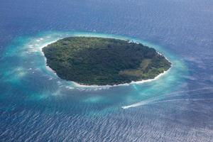 Aerial view of Maldives resort, luxury travel destination. Birds eye view of deep blue sea, coral reed, tropical island. Amazing nature view, drone aerial landscape photo