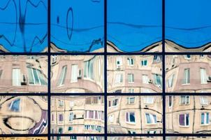 crooked reflection of houses in a glass window photo