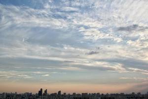 colorido crepúsculo nublado hermoso cielo paisaje urbano puesta de sol y amanecer por la mañana. vista espectacular de la noche por la mañana temprano con la silueta de los edificios de la ciudad. concepto de fondo panorámico. copiar espacio para texto foto