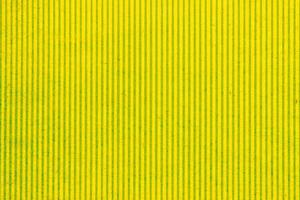 Fondo de líneas verticales de superficie rayada de textura simétrica geométrica amarilla de papel abstracto. telón de fondo de forma de cartón de diseño de estructura. concepto interior de decoración de primavera de vacaciones. plano, primer plano foto
