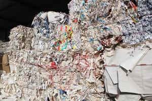 Wastepaper compact texture pile for recycling on sorting plant. Technology of reuse materials. Stack of shredded paper. Save the planet ecology concept. Industry of reduced pollution factory. Close-up photo