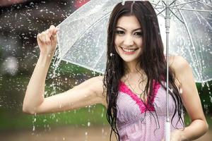 hermosa chica bajo la lluvia con paraguas transparente foto