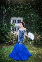 Beautiful lady in luxury blue dress with pearl photo