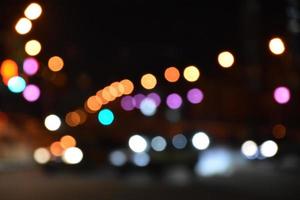 luces multicolores de la ciudad nocturna. calle nocturna iluminada con luces de coche. desenfocando las luces nocturnas de la ciudad. foto