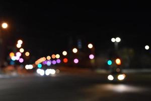 Multicolored lights of the night city. Illuminated night street with car lights. Defocusing the night lights of the city. photo