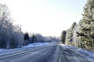 A high-speed road in a snow-covered field. Snowy road in winter. photo