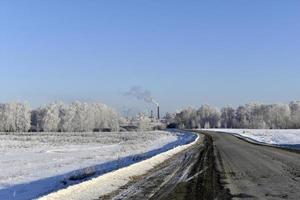 A high-speed road in a snow-covered field. Snowy road in winter. photo