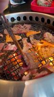 comida a la parrilla comiendo comida buffet en un restaurante japonés. buffet amante de la carne. gente asando carne. vídeos verticales.