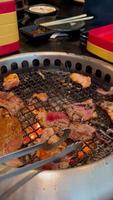 gegrilltes essen. Essen vom Buffet in einem japanischen Restaurant. Buffet für Fleischliebhaber. Leute, die Fleisch grillen. vertikales Video. video