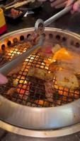 People eating Crispy pork belly stir fry with kale in white plate in the top view. Hand scooping a Crispy pork belly stir fry with kale for eating video