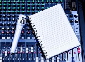 Top view sliver retro vintage microphone and notebook on console sound board mixer photo