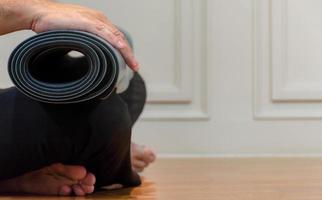 The man is using his hands to roll green yoga photo