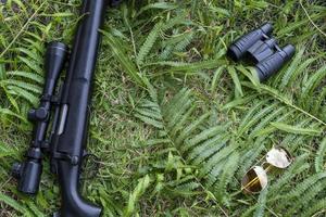 binoculares de vista superior y rifle en el suelo de hierba foto