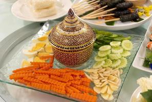 Porcelain cups, boiled eggs, carrots, ginger, along with salad rolls. Traditional Thai food. photo