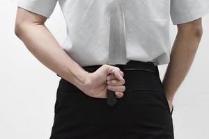 Blackmail concept Businessman hand and holding knife behind his back photo