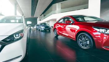 New cars parked in luxury showroom. Car dealership office. Car parked in showroom with care. Car for sale and rent business. Automobile leasing market. Electric vehicle. EV car dealer agent company. photo