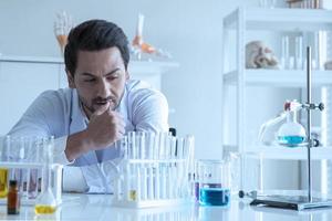 trabajador médico científico atractivo con tubo de ensayo de muestra en el laboratorio, haciendo un análisis en un laboratorio investigando para crear una vacuna y desarrollo foto