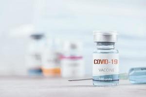 Blue vaccine jar bottle and syringe injection for treatment from corona virus infection and build immunity to viruses Covid-19 , Healthcare And Medical concept. photo