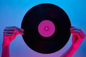 Woman hold retro vinyl disc in hands, toned photo