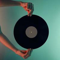 Woman hold retro vinyl disc in hands, toned photo