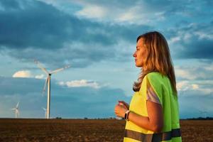 Engineer looks at wind turbine in the field photo