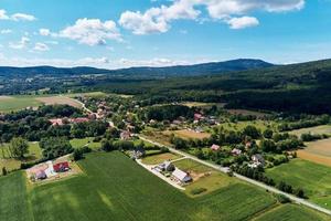 Village in mountains with forest, aerial view. Mountain landscape photo