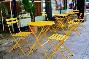 Street cafe interior with yellow table and chairs photo