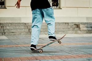 Skateboarder ride on skateboard at city street, close up photo