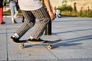 Skateboarder ride on skateboard at city street, close up photo