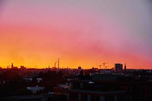 Sunset over city with buildings silhouette photo