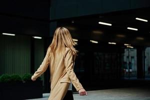 Woman in coat walks at city stret photo