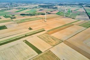 Windmill turbine in the field at summer day. Rotating wind generator photo