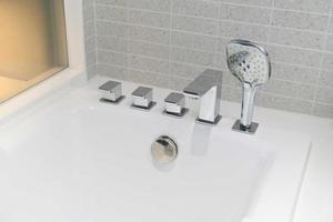 shower head and faucet bathtube in white bathroom photo