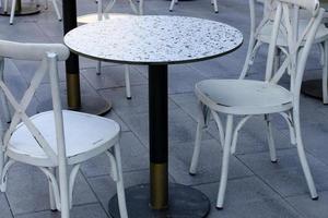 silla y mesa en un café en un parque de la ciudad cerca del mar. foto