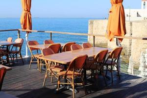 silla y mesa en un café en un parque de la ciudad cerca del mar. foto