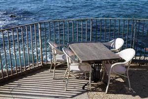 Chair and table in a cafe in a city park near the sea. photo