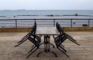 Chair and table in a cafe in a city park near the sea. photo