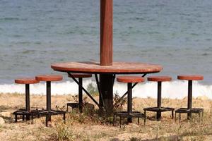 silla y mesa en un café en un parque de la ciudad cerca del mar. foto