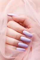 Girl's hands with a soft purple manicure. photo