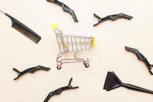 various hairdressing tools with shopping cart on a beige background. beauty salon concept photo