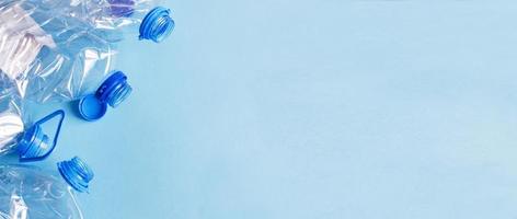 a lot of plastic empty rumpled used bottles on a blue background. waste and pollution concept photo
